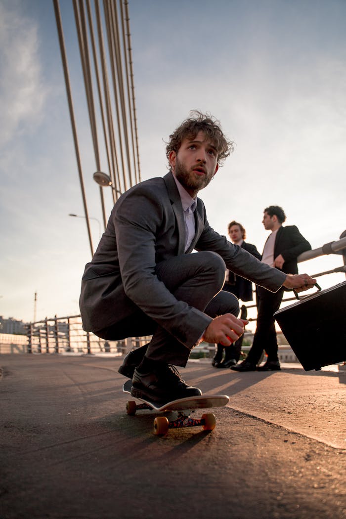 A Man in Gray Suit Riding a Skateboard